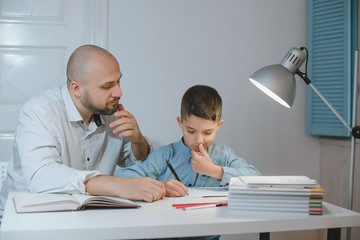 Father and son work together on school homework or homeschooling.