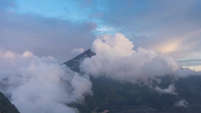 Sunset at Mount Rinjani Volcano on Lombok Indonesia 4K time-lapse. Clouds are passing by and a rainbow lights up the scenery during golden hour