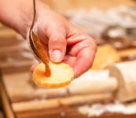 Konfitüre fließt von Löffel auf Keks