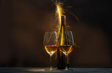 The fireworks blamed the background of a bottle of wine and two glasses filled with wine.