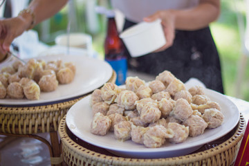 Vendor preparing Dim Sum Chinese Dumplings at shop.
