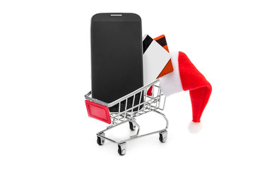 Smartphone with Santa's hat and credit card in shopping cart. Isolated on white.