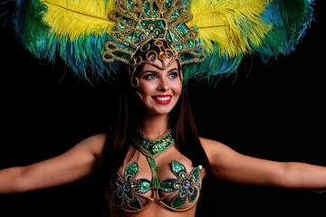Fototapeta na wymiar Brazilian woman posing in samba costume over black background