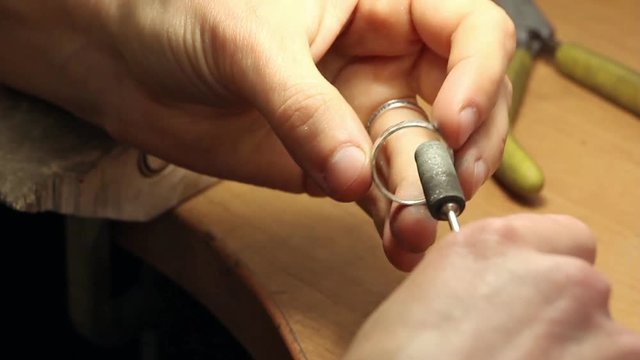 polishing the silver ring with the engraver (jewelry drill) and rotate it, workshop jewelry
