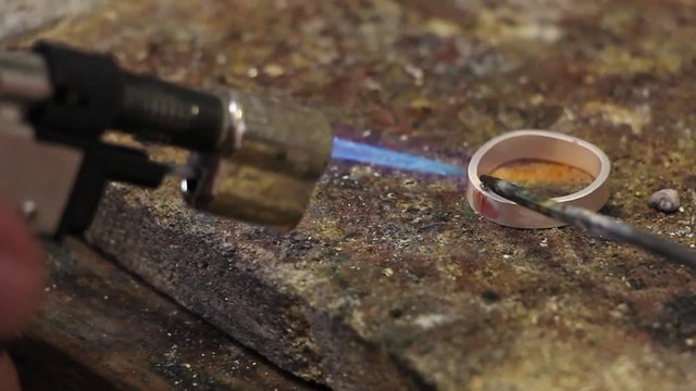 heating silver billet for ring by a burner and brazing it, solder application, metal workshop jewelry