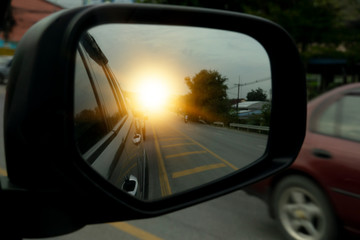 Side view of car mirror traffic of rear-end vehicles on the road with yellow line.