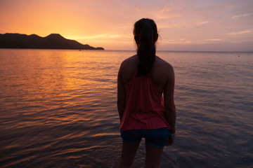 girl watching sunset at costa rica beach