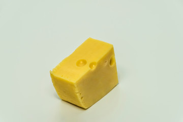 Yellow cheese with big holes and white background