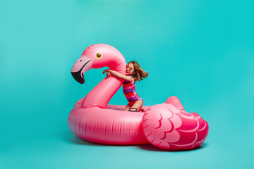 Girl on a giant inflatable flamingo imagining in the pool © Jacob Lund