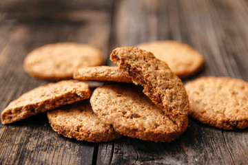 Integral cookies with cereal, dried fruit and chocolate on old wooden table