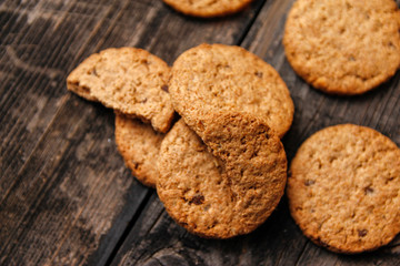 Integral cookies with cereal, dried fruit and chocolate on old wooden table