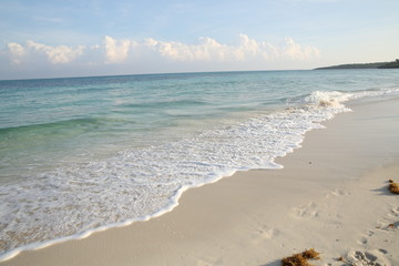 Fototapeta na wymiar footprints in the sand near the blue sea