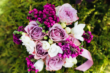 Close-up of a wedding bouquet of roses and lilacs on the backgro