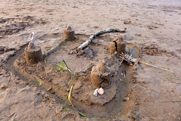 Eine Burg aus Sand mit Türmen und Wassergraben. 