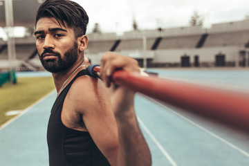 Athlete standing in a track and field stadium holding a javelin