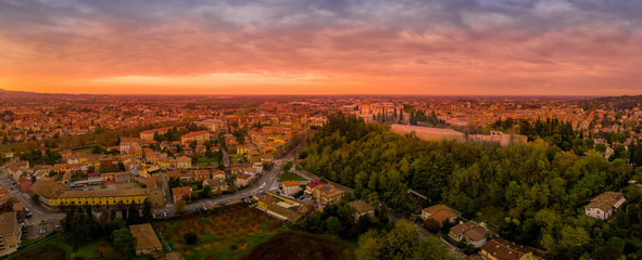 Fototapeta na wymiar Sunset aerial panorama of Cesena in Emilia Romagna Italy near Forli and Rimini, with the medieval Malatestiana castle, Piazza del Popolo and Roman Catholic churches and cathedral on a winter afternoon