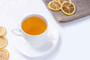 Orange herbal flavored christmas tea with cinnamon and cardamom honey white cup on a white wooden table