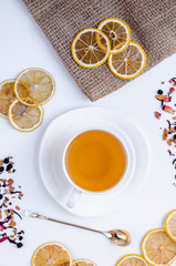 Obraz na płótnie Canvas Orange herbal flavored christmas tea with cinnamon and cardamom honey white cup on a white wooden table