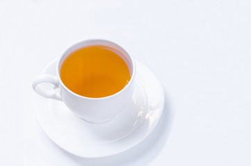 Orange herbal flavored christmas tea with cinnamon and cardamom honey white cup on a white wooden table