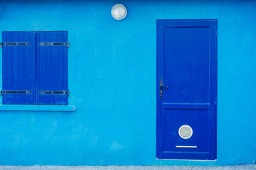 Facade of blue building with blue doors and shutters
