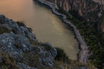 soft focus narrow sea bay aerial photography from above with with rocky stones on foreground and water between mountains on background in twilight darkness evening environment 