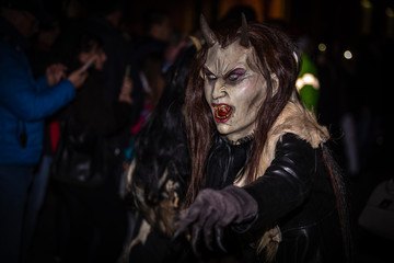 Closeup on female horned devil in traditional krampuslauf with wooden masks in Retz, Austria. The Krampus is in the tradition of a fright figure in the company of St. Nicholas