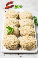 Raw meat fritters and ingredients on a cutting board, ready for cooking. Selective focus, space for text.