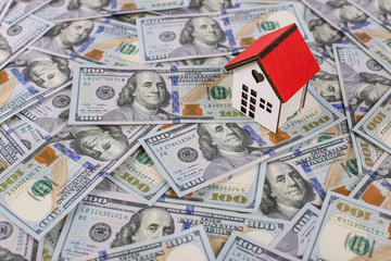 american dollars in one hundred banknotes and model house.  Lot of dollars close up