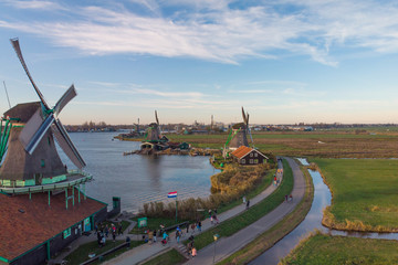 Dutch windmill aerial panoramic landscape with a row of windmills at sunset on a bright day with blue sky