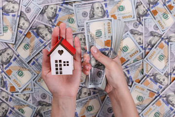 american dollars in one hundred banknotes and model house.  Lot of dollars close up