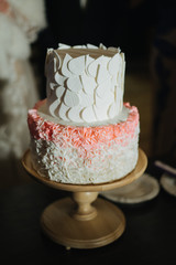 beautiful wedding cake on a stand with pink and white decorations