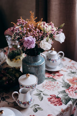 Obraz na płótnie Canvas flowers in a vase with cup of tea