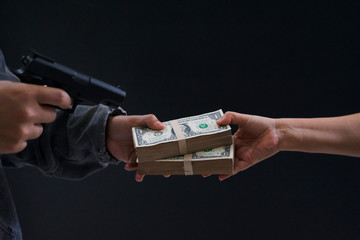 Gun and money in a hands. Bank robbery, Man carrying a gun to rob the money. To threaten with the gun man