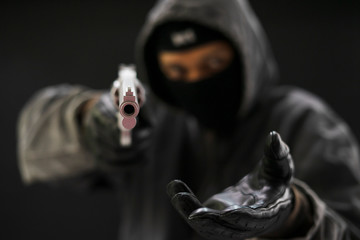 Robber with a gun robbing intimidate.Crime and robbery concept.