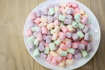 Multicolored marshmallows on a white plate.