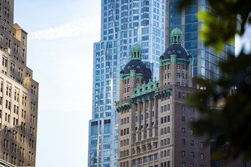 Fototapeta na wymiar (selective focus) Close-up view of some huge buildings and beautiful skyscrapers in Manhattan, New York City, USA.