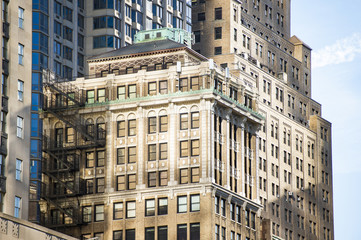 Fototapeta na wymiar Close-up view of some huge buildings and beautiful skyscrapers in Manhattan, New York City, USA.