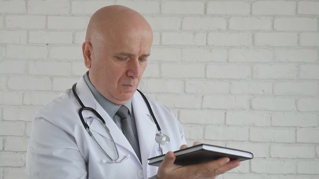 Slow Motion with Serious Doctor Writing Medical Notes in Agenda in Hos[ital