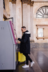Young man buying train ticket