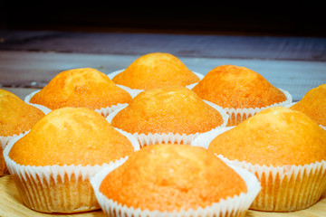 Freshly baked obscene in baskets on a wooden table in the form of a pyramid with a dark background.