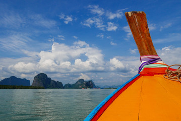 Traditional wooden boat on tropical sea, sky & mountain in summer in Thailand, Phang Nga bay national park for vacation, summer, holiday concept