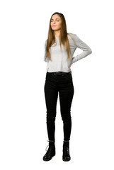 Full-length shot of young girl suffering from backache for having made an effort on isolated white background