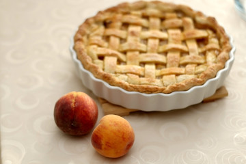 Homemade baked peach pie, served on a table. Selective focus.