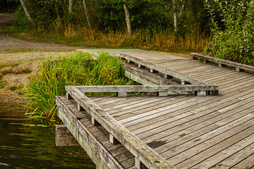 Fototapeta na wymiar fishing dock over a lake with green foliage