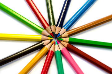 Color pencils pink light blue green yellow and red on white background.