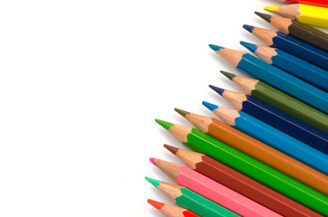 Color pencils pink light blue green yellow and red on white background.
