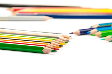 Color pencils pink light blue green yellow and red on white background.