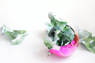 broken Christmas ball, shards, scattered rumpled banknotes, the concept of a bad Christmas, a bad and expensive new year