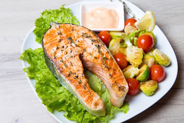 Grilled salmon with brussels sprouts and tomatoes. Close-up, selective focus.