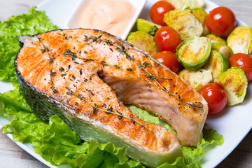Grilled salmon with brussels sprouts and tomatoes. Close-up, selective focus.